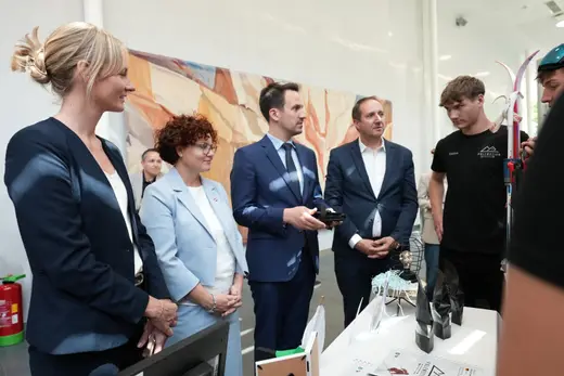 Gäste lassen sich am Stand einer Junior Company das Produkt erklären