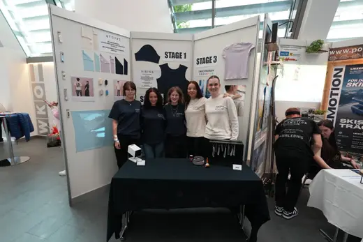 Team einer Junior Company in einheitlichen Shirts am Messestand