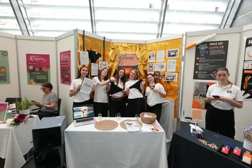 Junior Company vor ihrer goldenen Standrückwand